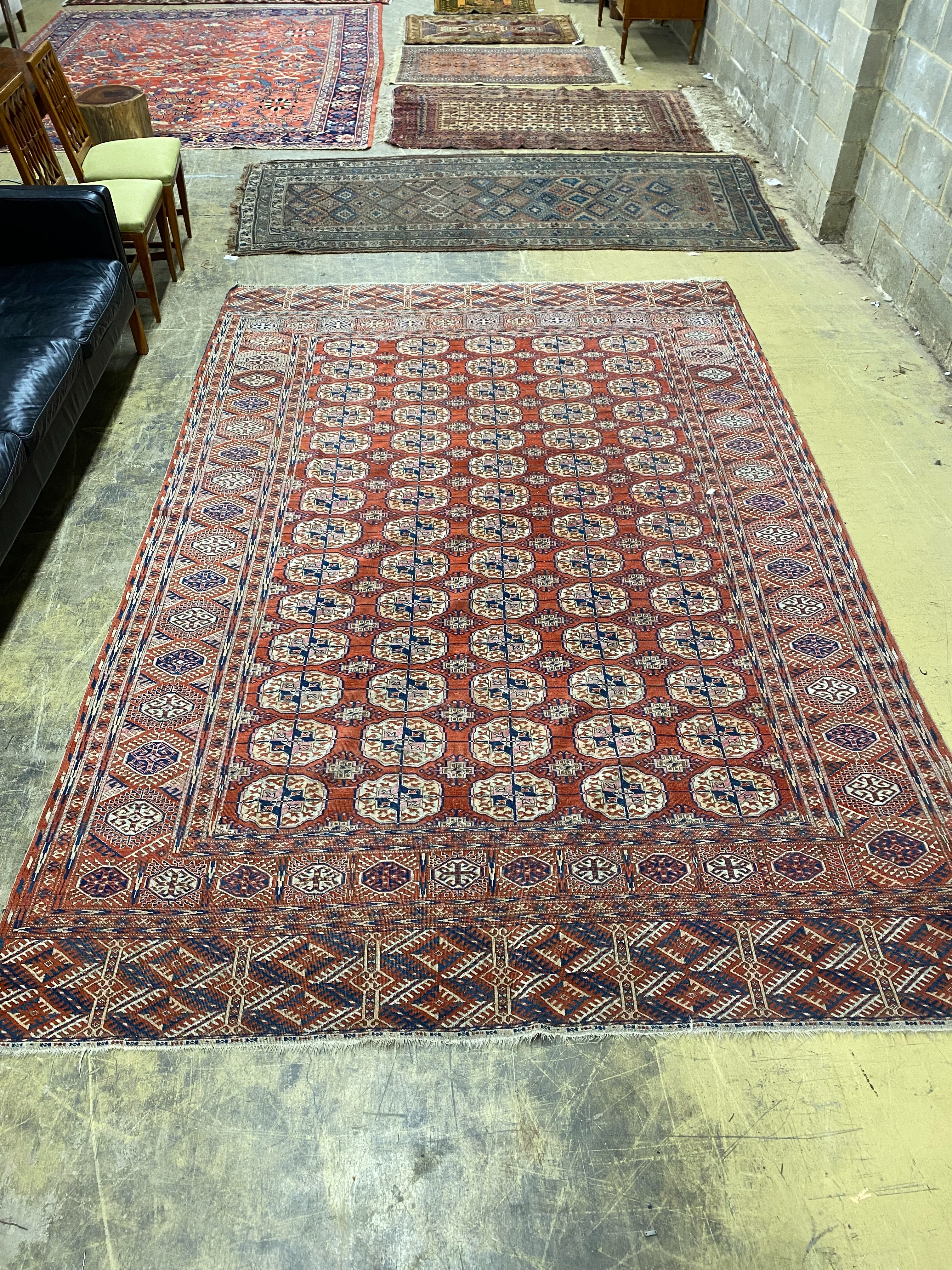 A Bokhara brick red ground carpet, 350 x 230cm